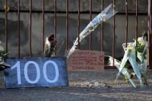 Photo prise le 2 septembre 2019 montrant quelques fleurs et un panneau indiquant le chiffre 100 sur le lieu où a été trouvé le corps d'une femme, victime de féminicide à Cagnes-sur-Mer (Alpes-maritime