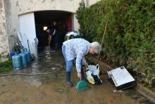 Les riverains sinistrés de Villeneuve-les-Beziers, dans le sud de la France , nettoient leurs maisons inondées par les intempéries, le 24 octobre 2019