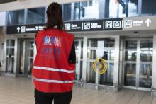 Une personne de L'Office français de l'immigration et de l'intégration (OFII) attend l'arrivée de migrants à l'aéroport de Colombier, le 18 octobre 2018 à Colmbier-Saugnieu, près de Lyon
