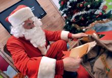 Un employé de la Poste de Libourne déguisé en père Noël ouvre des lettres envoyées du monde entier à l'occasion de Noël, le 8 décembre 2010 dans le centre de tri de Libourne