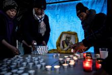 Des demandeurs d'asile tibétains dans les Yvelines prient devant un portrait du Dalai Lama, le 2 décembre 2019
