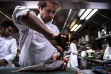 Le chef du restaurant Lucas Carton, Julien Dumas, prépare un poisson en cuisine, le 12 décembre 2019 à Paris
