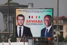 Une affiche montrant Emmanuel Macron (g) et son homologue ivoirien Alassane Ouattara à Abidjan le 19 décembre 2019