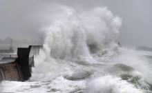 Un bateau de pêche passe le 9 février 2020 devant le phare de New Brighton, dans le nord-ouest de l'Angleterre, où la tempête Ciara est arrivée