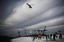 Un hélicoptère dépose de la neige sur une piste de la station de ski Superbagnères, le 15 février 2020