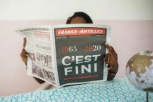 Un homme lit le journal "France-Antilles", placé en liquidation judiciaire sans poursuite d'activités, le 30 janvier 2020 à Pointe-à-Pitre, en Guadeloupe