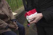 Un policier saisit des cigarettes de contebande vendues dans la rue à Aubervilliers en 2015