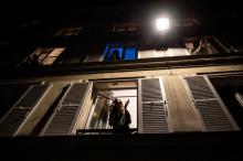 Des Français applaudissent les soignants depuis leur fenêtre, à Paris, le 18 mars 2020