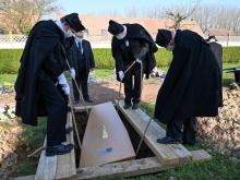 Des memebres de la confrérie des "Charitables" mettent en terre un cerceuil au cimetière de Béthune, le 27 mars 2020.