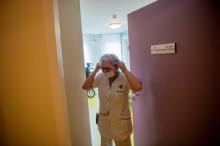 Une infirmière met un masque de protection avant de voir un patient malade, le 4 mars 2020 dans un Ehpad à Brest