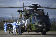 Des siognants chargent un malade du coronavirus dans un hélicoptère militaire, le 30 mars 2020 à l'aéroport de Strasbourg-Entzheim.