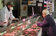 Une femme fait ses courses le 23 mars 2020 dans un supermarché de Saint-Etienne qui réserve sa première heure d'ouverture aux seniors