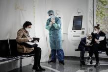 Un soignant d'un centre médical va tester un patient pour le COVID-19, le 27 mars 2020 à Paris