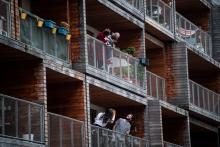 Discussion entre voisins depuis leur balcon, à Paris le 20 mars 2020