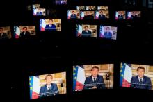 Emmanuel Macron sur des écrans de tablette alors qu'il parle depuis l'Elysée lors d'une allocution télévisée, le 13 avril 2020 à Paris