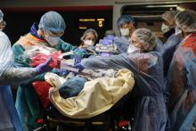 Du personnel soignant embarque un patient contaminé au Covid-19 à bord d'un TGV médicalisé, le 1er avril 2020 à la Gare d'Austerlitz, à Paris