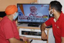 Des Indiens regardent depuis leur résidence à Amristar la télévision pour suivre l'allocution du Premier ministre Narendra Modi, le 14 avril 2020