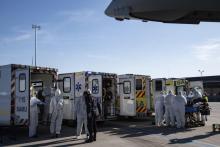 Du personnel soignant transporte des malades gravement atteints par le Covid-19 dans des avions, stationnés sur le tarmac de l'aéroport de Orly le 4 avril 2020