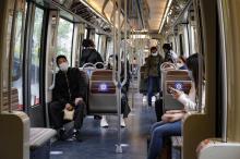 Des usagers portent des masques de protection, assis à distance les uns des autres, dans une rame de métro, le 11 mai 2020 à Paris, au premier jour du déconfinement en France