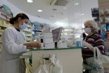 Une pharmacienne sert un client derrière un plexiglas protecteur (Hygiaphone) à Nice, le 2 mai 2020