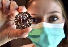 Un membre du personnel soignant montre la médaille créée par la Monnaie de Paris, en hommage aux corps médical, éboueurs, caissiers, agriculteurs etc., le 15 mai 2020 à Pessac, en Gironde