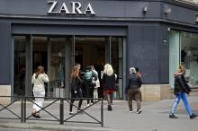Des personnes entrent dans une boutique de vêtements Zara, le 11 mai 2020 à Paris, au premier jour du déconfinement en France