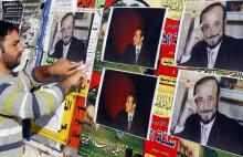 Un homme colle des affiches de Rifaat al-Assad, l'oncle du président syrien, le 6 décembre 2007 à Tripoli