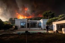 Un homme arrose sa maison pour la protéger d'un incendie à La Couronne, près de Marseille, le 4 août 2020