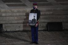 Un garde républicain tient le portrait de l'enseignant assassiné Samuel Paty lors de l'hommage national lui étant rendu le 21 octobre 2020 à la Sorbonne à Paris