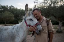 Luis Manuel Bejarano, président de l'association "El Burrito Feliz", et un de ses ânes employés pour des séances de thérapie pour soignants, le 8 septembre 2020 à Hinojos, dans le sud de l'Espagne