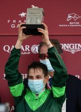 Le jockey italien Cristian Demuro soulève son trophée après sa victoire dans le Prix de l'Arc de Triomphe, le 4 octobre 2020 à Paris