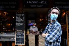 Un restaurateur devant son établissement vend nourriture et boissons à emporter à Paris, le 9 mai 2020