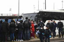 Des migrants attendent d'être évacués d'un campement au pied du Stade de France, à Saint-Denis le 17 novembre 2020