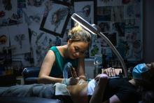 Ngoc Like réalise un tatouage sur le ventre d'une cliente dans son studio de Hanoï, le 20 mars 2021 au Vietnam