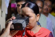 Une Indienne place son oeil sur un capteur optique afin d'enregistrer ses données biométriques destinées à sa carte d'identification unique Aadhaar, à Amritsar le 17 juillet 2018