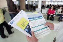 Une personne présente les brochures informant sur le RSA , quelques jours après son entrée en vigueur, le 4 juin 2009 à Paris