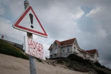 Des villas jumelles construites sur une dune de sable sur la côte de la station balnéaire, risquent de s'effondrer à cause de l'érosion, le 22 octobre 2021