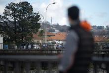 Un migrant regarde une patrouille de police sur le pont de Santiago entre Irun (Espagne) et Hendaye (France), le 11 janvier 2022