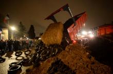 Des agriculteurs déversent des déchets et de la paille devant la préfecture de la Sarthe au Mans le 15 février 2022 lors d'une manifestation pour réclamer de meilleurs prix pour leur production