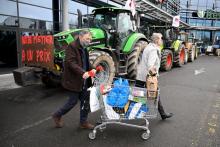 Des clients d'un supermarché quittent le magasin devant lequel des agriculteurs manifestent pour réclamer une revalorisaton des prix de leurs productions, le 4 février 2022 à Rennes