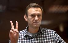 L'opposant russe Alexeï Navalny fait le signe de la victoire depuis son box vitré durant une audience du tribunal de Babouchkinski à Moscou, le 20 février 2021