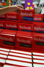 Une jeune fille achète un "Bescherelle", le manuel de conjugaison, le 2 août 2004 dans une grande surface de Rots, dans le Calvados