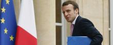 Emmanuel Macron de trois quart, un dossier à la main devant l'Elysée