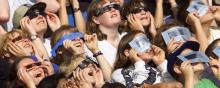 Des enfants regardent une éclipse avec des lunettes spéciales.