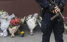 Un policier et des fleurs  devant le bar Le Carillon, visé par les attentats du 13 novembre 2015.