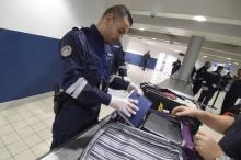 Un douanier inspecte la valise d'un voyageur à Roissy