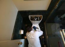Un plombier répare des toilettes.