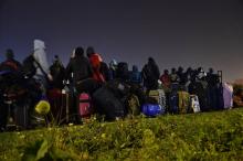 Des migrants de la Jungle de Calais font la queue durant l'évacuation du camp.