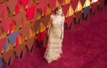 Sacrée meilleure actrice, Emma Stone arrive sur le tapis rouge de la cérmonie des Oscar, le 26 févri
