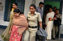 La police indienne escorte Chandana Chakraborty (D) et Sonali Mondal (G), dans l'enquête sur un traf